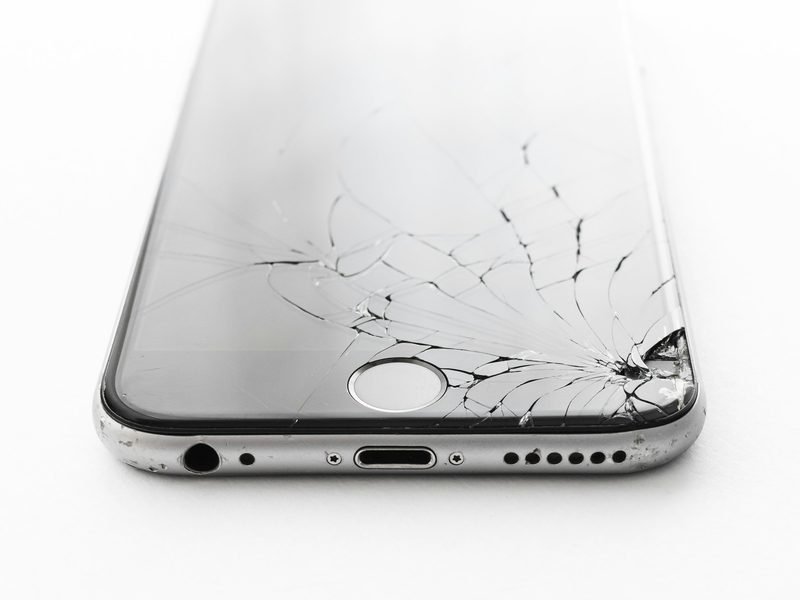 A smartphone with a badly cracked glass screen